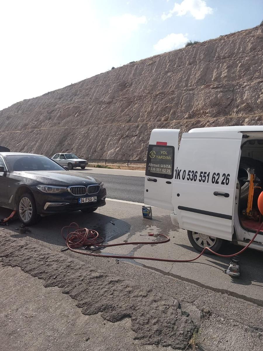 Otoban kenarında binek aracın lastiğini yerinde değiştiren seyyar lastikçi