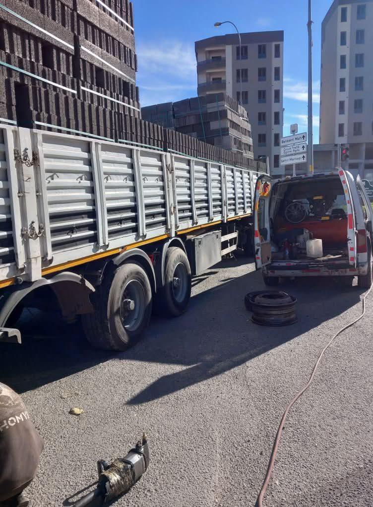 Tuğla yüklü tırın lastiğini yol kenarında değiştiren yol yardım ekibi